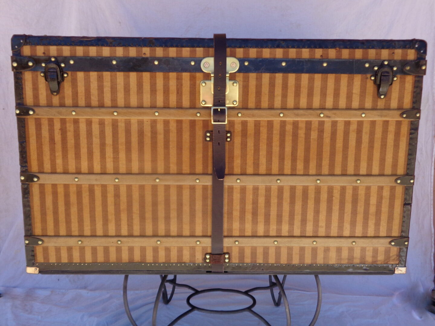 Vintage striped steamer trunk on metal stand